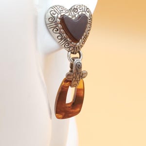 May include: A white ceramic mug with a black handle and the text "But First, Coffee" in a bold, black font. The mug is set against a neutral background, highlighting its simple design.