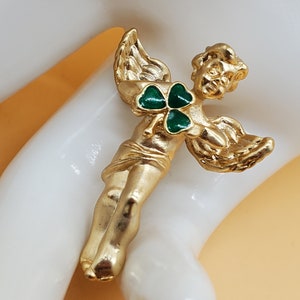 Vintage Avon gold tone angel pin with a green clover