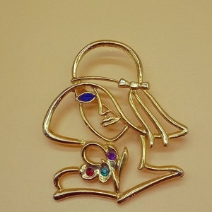 Vintage JJ 1988 gold tone openwork woman face brooch with rhinestones accents