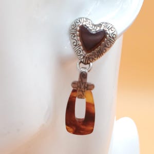 May include: A white ceramic mug adorned with a vibrant floral pattern. The design incorporates pink, purple, and yellow flowers. The mug has a white handle. Suitable for hot drinks, this mug is a decorative item.