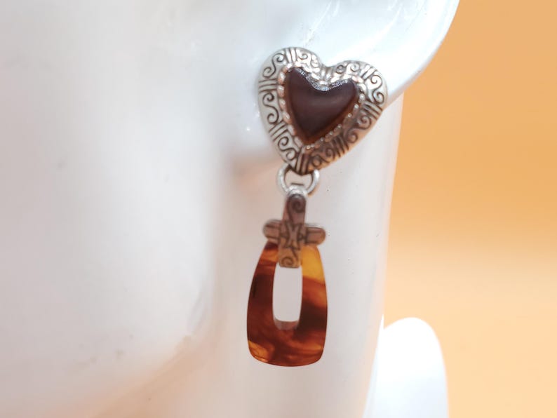 May include: A white ceramic mug adorned with a vibrant floral pattern. The design incorporates pink, purple, and yellow flowers. The mug has a white handle. Suitable for hot drinks, this mug is a decorative item.