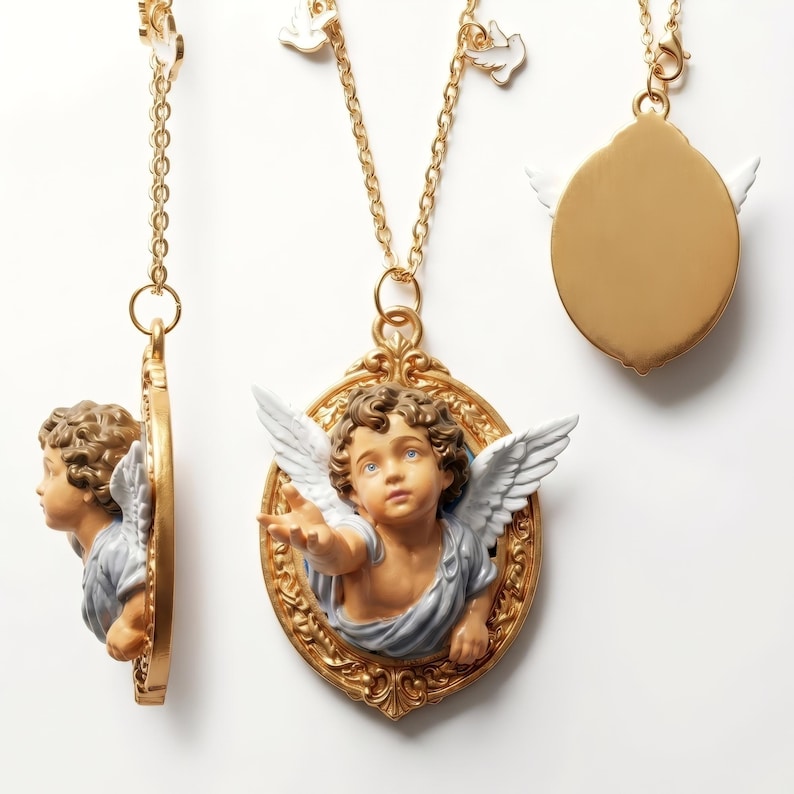 Puede incluir: Collares dorados con colgantes de querubines. Los colgantes presentan un querub&iacute;n detallado con alas blancas y una t&uacute;nica azul y gris, en un marco dorado ornamentado. Los collares tienen una cadena delicada y un peque&ntilde;o dije de paloma.