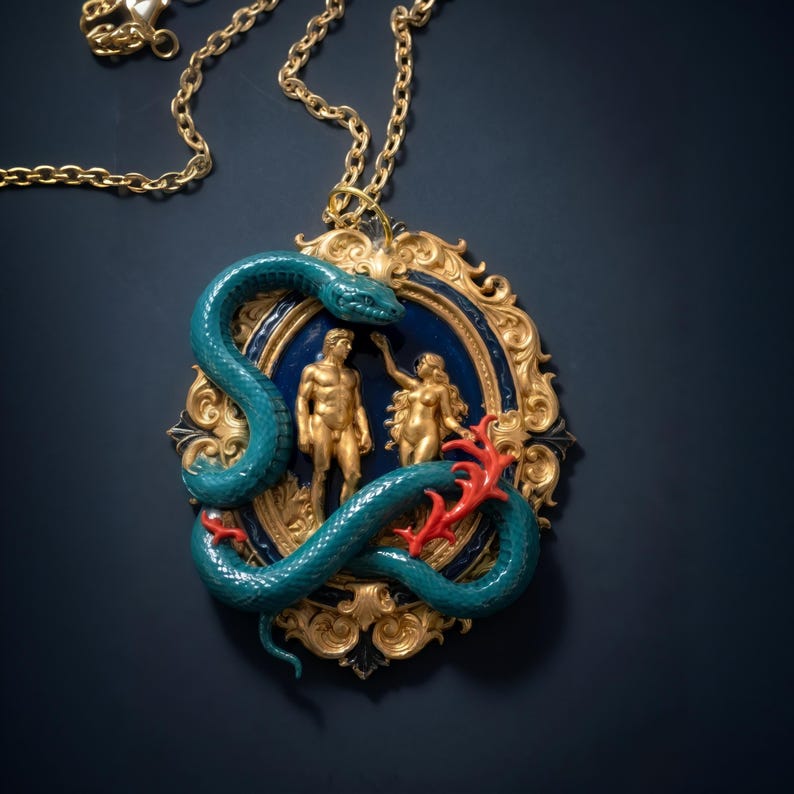 May include: A gold-toned pendant necklace featuring a teal snake coiled around a framed scene with gold figures of a man and woman. The frame has a blue background and ornate gold detailing, with red coral accents.