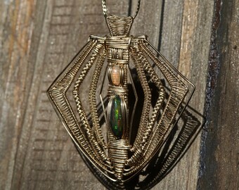 May include: A gold wire wrapped pendant featuring a green and pink opal gemstone. The pendant is shaped like a diamond and has a geometric design.