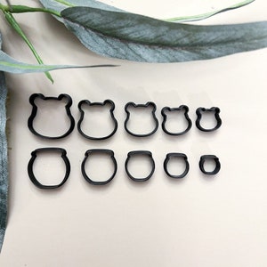 May include: A set of ten black metal cookie cutters in various sizes, featuring frog and pot shapes.