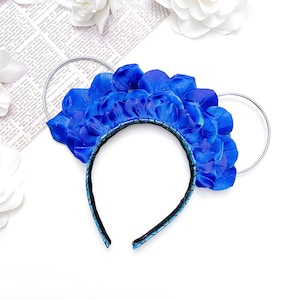 May include: Blue flower petal headband with silver metal ears. The headband is black with a blue and black pattern.