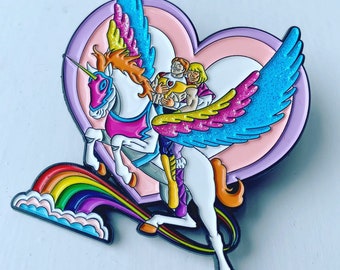 May include: A colorful enamel pin featuring two figures riding a winged unicorn with a rainbow tail. The unicorn is white with a pink saddle and a gold horn. The figures are wearing colorful outfits and are holding each other. The background is a pink heart with a white center.