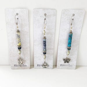 Bellissimi pendenti di perline di carta per diari spazzatura con design originale in linoleum, rose vintage e ciondoli in argento