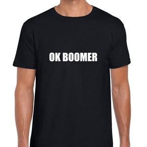 Könnte beinhalten: Schwarzes T-Shirt mit dem Aufdruck "OK BOOMER" in weiß auf der Vorderseite.