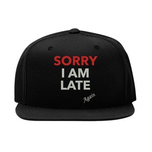 May include: Black baseball cap with white text that reads "SORRY I AM LATE Again". The text "SORRY" is in red.