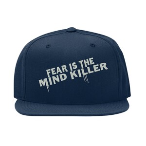 May include: A navy blue baseball cap with the text "FEAR IS THE MIND KILLER" in white lettering.