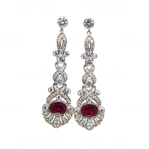 May include: A pair of silver dangle earrings with red gemstones and clear cubic zirconia stones.