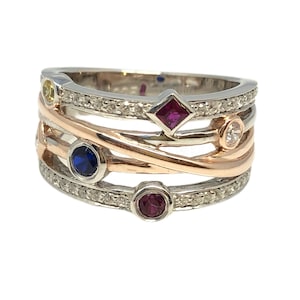 Puede incluir: Un anillo de piedras preciosas multicolores con una banda retorcida. El anillo presenta un zafiro azul, un rubí rojo, un zafiro amarillo y un diamante blanco. La banda está hecha de oro blanco y oro rosa.
