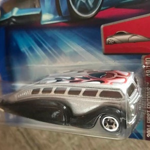 May include: A silver and black toy car with red and white flames on the roof. The car is a 2004 First Editions Hot Wheels model, number 49/100, and is called "Crouze Low Flow".