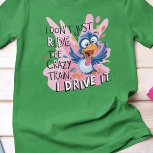 Camiseta divertida de tren loco: "No solo lo monto, lo conduzco". Camiseta con un pájaro colorido. Camiseta gráfica divertida para mujer y hombre.