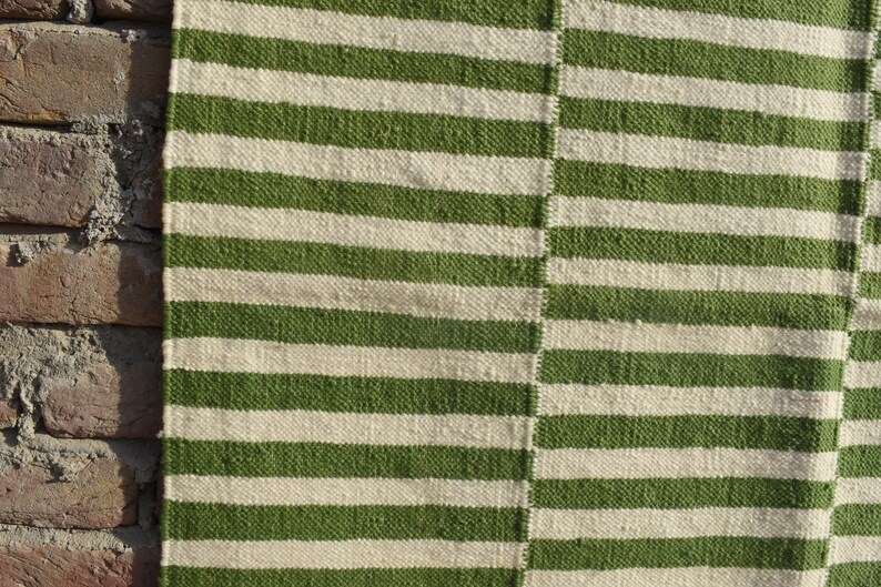 May include: Green and white striped woven rug with a textured surface.