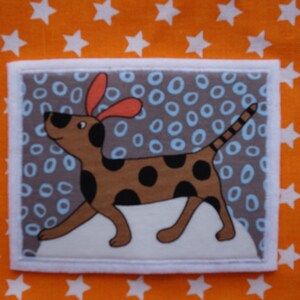 May include: A brown and black spotted dog with orange ears is on a grey background with blue and white circles. The dog is looking to the left.