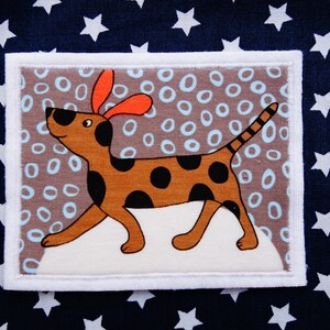 May include: A brown and black spotted dog with orange ears is walking on a white background with a brown and blue patterned border. The dog is surrounded by white circles on a brown background.
