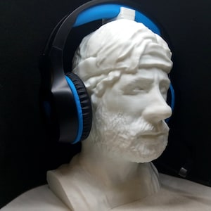 Könnte beinhalten: Eine weiße 3D-gedruckte Büste einer Person, die ein schwarzes und blaues Headset trägt. Das Headset hat ein blaues Kopfband und schwarze Ohrmuscheln.