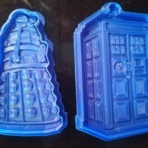 May include: Two blue 3D printed cookie cutters, one shaped like a Dalek from Doctor Who and the other shaped like the TARDIS.
