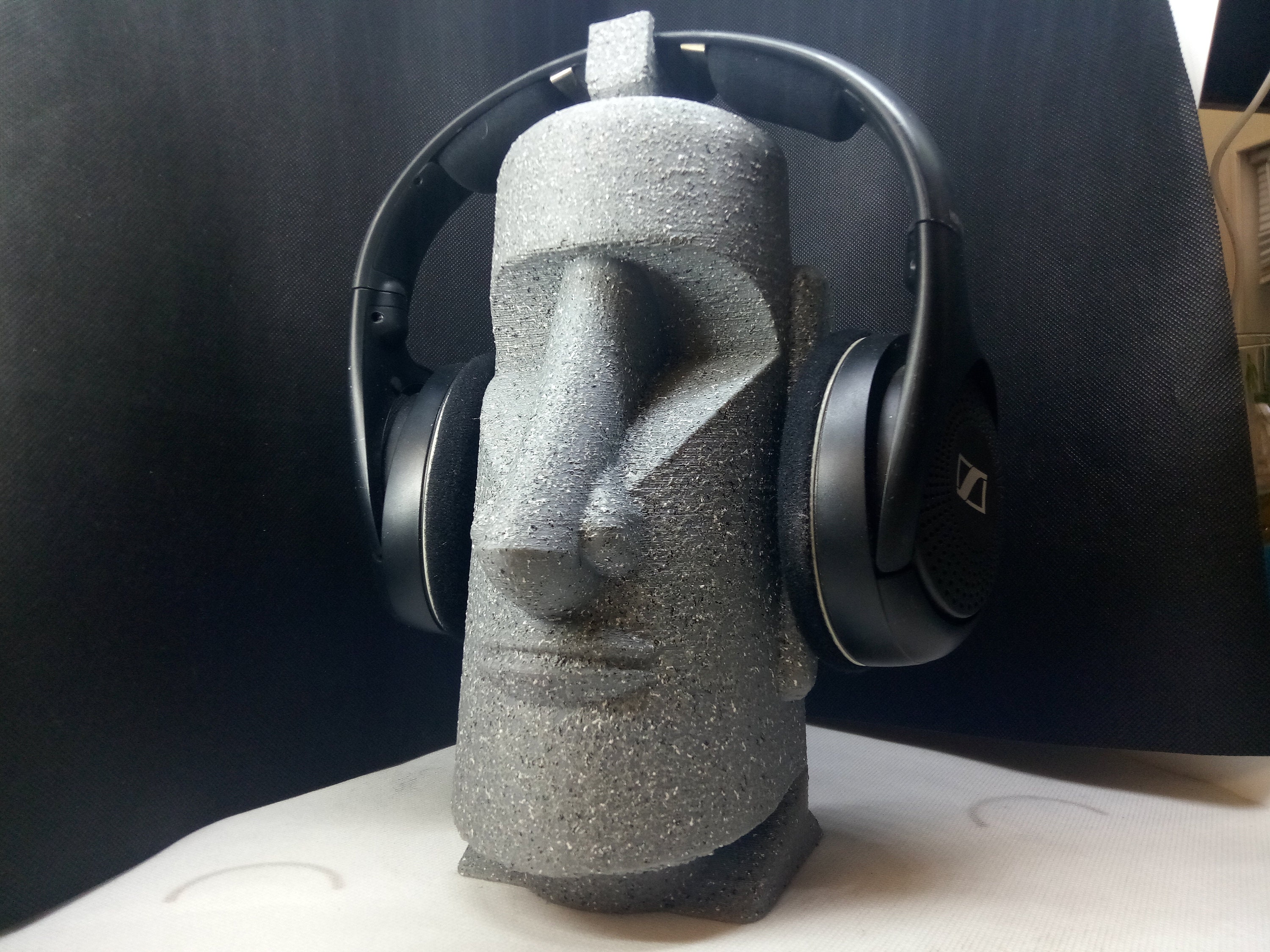 Humorous moai sculpture with pilot helmet