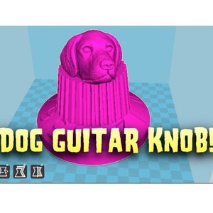 May include: A pink 3D printed guitar knob shaped like a dog's head. The knob is designed to be used on a guitar or other musical instrument. The text "DOG GUITAR KNOB!" is printed in yellow letters on a black background.