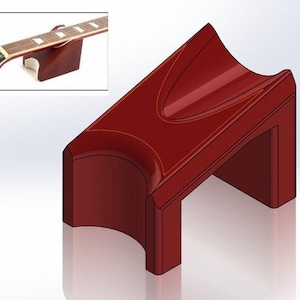 Puede incluir: Un soporte rojo para el mástil de la guitarra con una cuna curva y una base rectangular. La imagen insertada muestra un mástil de guitarra apoyado en un soporte similar. El soporte está diseñado para sujetar un mástil de guitarra.