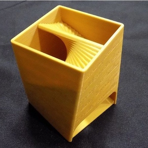 May include: A yellow plastic dice tower with a curved, angled slot for rolling dice.