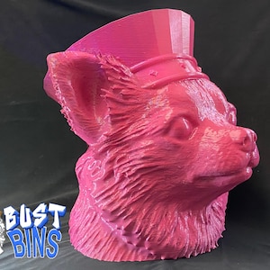 May include: A pink 3D-printed bust of a fox wearing a hat. The fox has detailed fur texture and is painted in shades of pink. The bust is a decorative item, likely for home decor or as a unique gift.