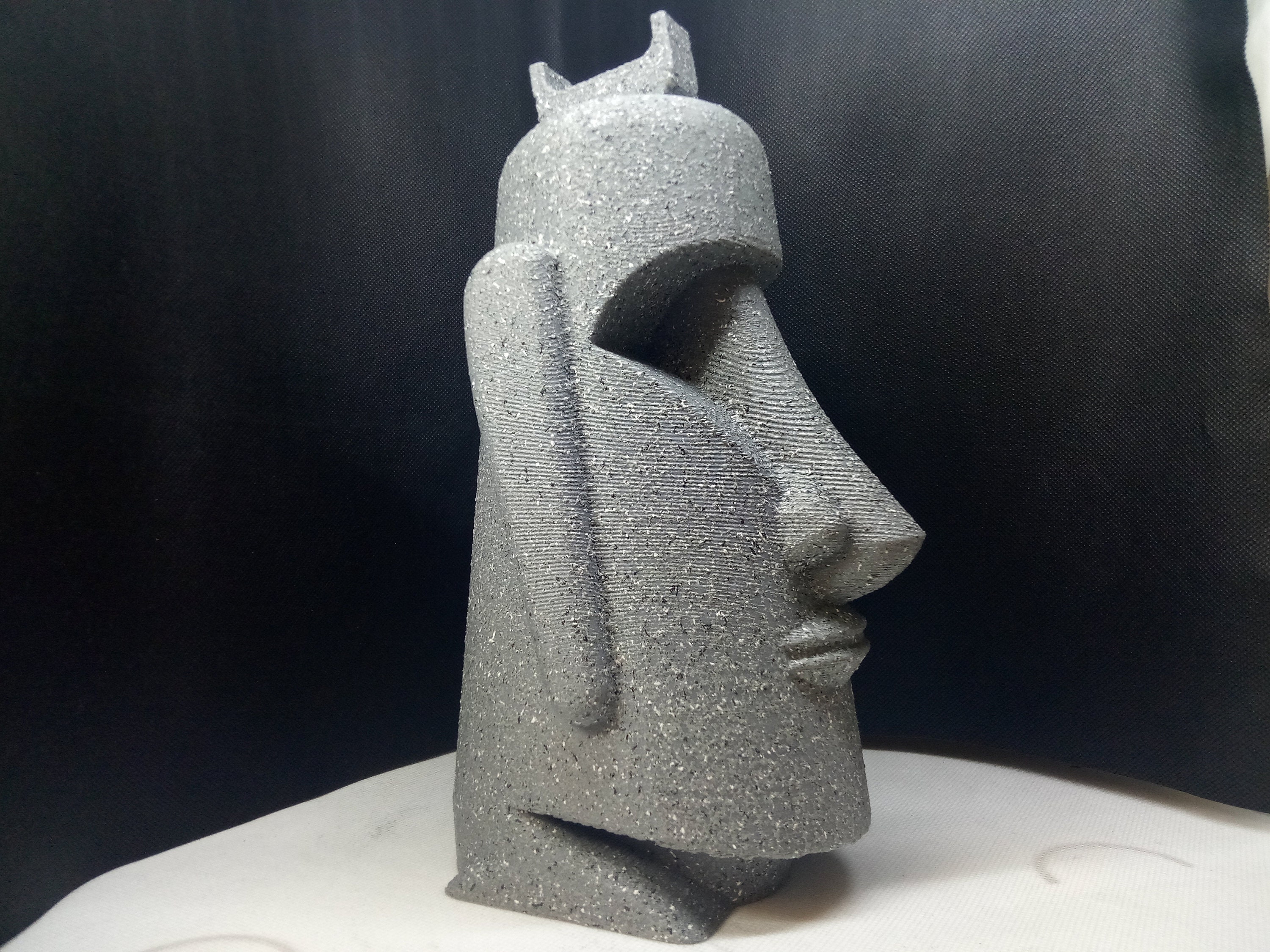 Humorous moai sculpture with pilot helmet