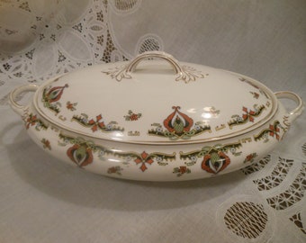 May include: An oval white serving dish with a lid. The dish has a gold trim and a floral design in shades of red, green, and black.