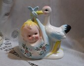 Sweet Vintage Inarco Stork Carrying Baby Planter Blue Blanket Pink Flowers White Gray Bird Yellow Beak Legs Feet Pink Head Blue Shadow