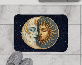 May include: A rectangular bath mat featuring a celestial design. The image depicts a crescent moon and a sun with human faces, set against a starry night sky. The color palette includes gold, blue, and cream.
