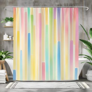 May include: A colorful shower curtain with vertical stripes in pastel shades of yellow, pink, blue, and green. The design features a watercolor effect, creating a soft and inviting aesthetic. The curtain is hung on a silver rod.