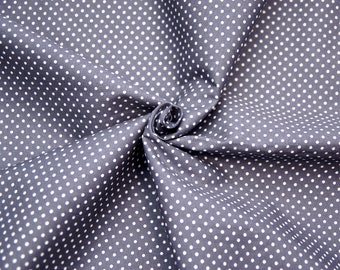 May include: Close-up of a gray fabric with a white polka dot pattern. The fabric is folded and twisted, creating a swirling effect.