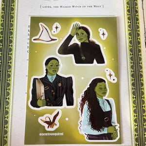 May include: A set of four stickers featuring illustrations of Elphaba, the Wicked Witch of the West, from the musical Wicked. The stickers include Elphaba wearing a witch's hat, Elphaba wearing a striped suit and holding a book, Elphaba wearing a blue dress and a green bird.