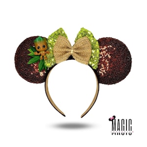 May include: Brown sequined mouse ears with a burlap bow and green sequined bow accents. A small Groot figure and green leaves are attached to the left ear. The headband is brown.