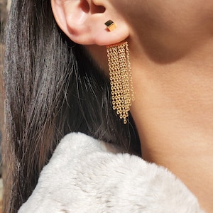 May include: Gold chain earrings with a square-shaped top and a long, dangling chain design.
