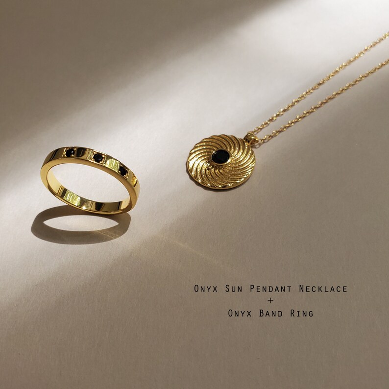Op de afbeelding: Een gouden ketting met een zwarte onyx zon hanger en een gouden bandring met zwarte onyx stenen. Onyx zon hanger ketting + Onyx bandring.