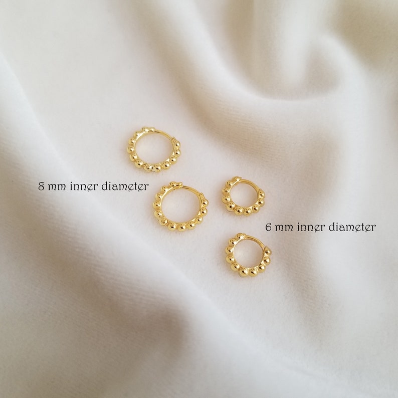 May include: Three gold hoop earrings with a beaded design. The earrings have inner diameters of 8 mm, 6 mm, and 6 mm.