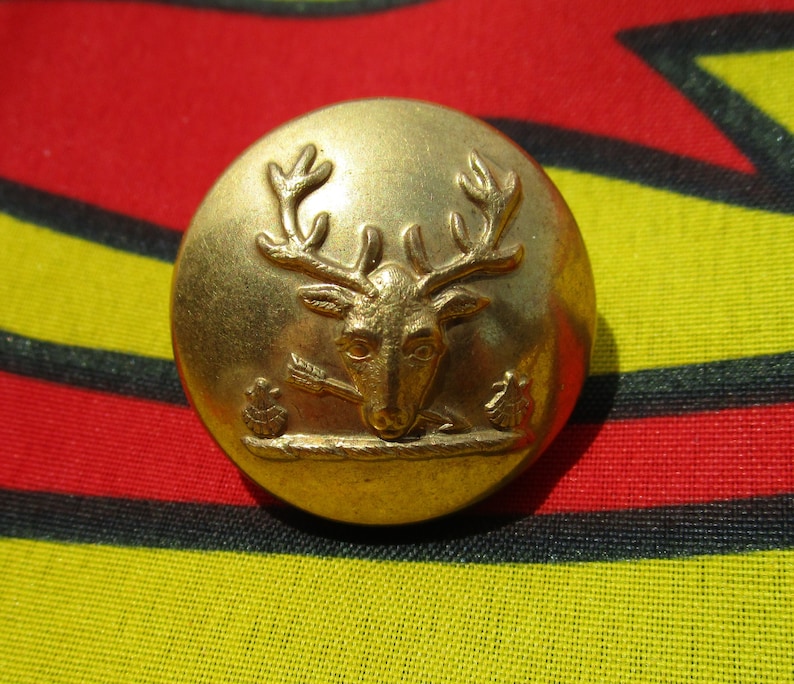 Antique Livery Button of a deer hart stag holding an arrow with two shells Pitt