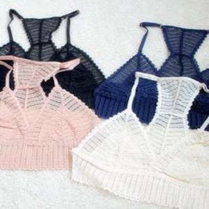 Puede incluir: Cuatro bralettes de encaje en negro, azul marino, rosa y blanco. Las bralettes tienen un delicado patrón de encaje y un escote en V.