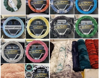 May include: A collection of plush steering wheel covers in various colors and patterns, including evergreen heather, ginger galaxy, saltwater galaxy, navy fawn, peacock hide, galaxy lemon drop, black hide, evergreen glacier, sterling silver fox, flamingo glacier, and cow print. The covers are made of soft, fuzzy fabric and feature the text "Little Minky Luxuries".