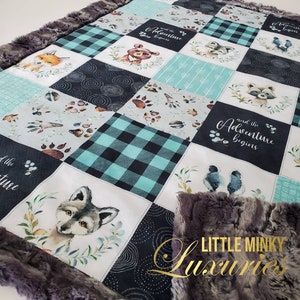 May include: A soft, plush baby blanket with a patchwork design featuring woodland animals, paw prints, and the text "And the Adventure Begins". The blanket is made of a combination of black, white, and teal fabrics.