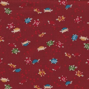 Op de afbeelding: Bordeauxrode stof met een herhaald patroon van kleurrijke schildpadden en kleine rode cirkels. De schildpadden zijn in verschillende kleuren, waaronder blauw, groen, geel en wit, met bloemmotieven op hun schilden.