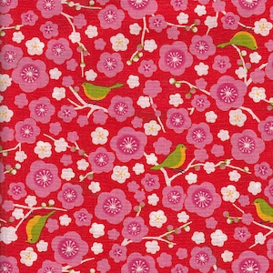 Op de afbeelding: Een felrode stof met een herhalend patroon van roze kersenbloesems, kleine witte bloemen, groene bladeren en geelgroene vogels op witte takken. Het ontwerp is dicht en gedetailleerd.