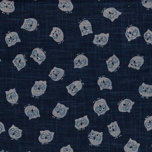 Peut inclure: Un tissu bleu avec un motif répétitif de hiboux blancs. Les hiboux sont tous tournés vers l'avant, les yeux fermés.