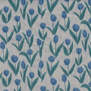 May include: A fabric with a repeating pattern of blue tulip flowers and green leaves on a light beige background. The floral design is evenly spaced across the fabric, creating a consistent and visually appealing pattern.