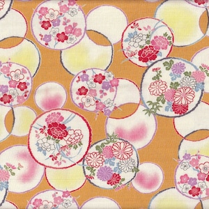 May include: A fabric featuring a repeating pattern of floral circles in white, pink, red, and purple on a golden-orange background. The circles overlap, creating a layered effect. The floral designs include various flower types.