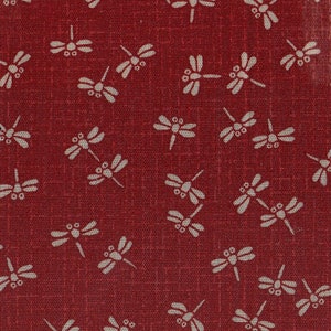 May include: Red fabric with a white dragonfly pattern. The dragonflies are scattered across the fabric in a random pattern.